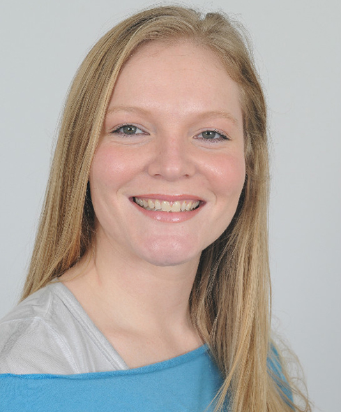 A woman with long blonde hair smiles for the camera.