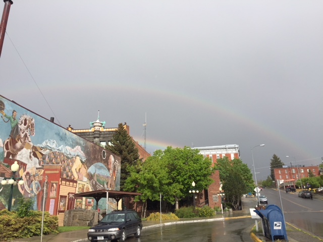 A rainbow is seen in the sky over a city.